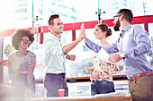 Business people high fiving in meeting