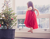 Girl next to potted Christmas tree
