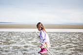 Girl with stick playing on beach