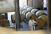 Vintner in lab coat examining wine