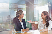 Businesswomen talking in sunny conference room