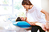 Masseuse stretching woman's arm