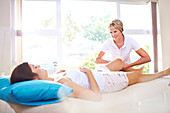 Masseuse massaging woman's leg