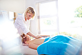 Physical therapist massaging woman's back
