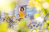 Smiling woman with bicycle in city