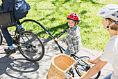 Boy riding tandem bicycle with father
