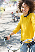 Portrait smiling woman on bicycle in park
