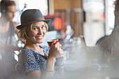 Woman in hat drinking espresso