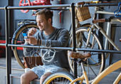 Young man texting near bicycles