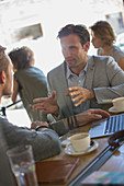 Businessmen talking and gesturing at cafe