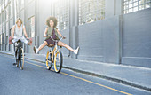 Playful women coasting on bicycles