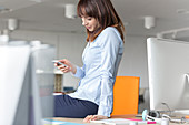 Brunette businesswoman texting on desk