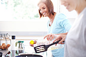 Smiling women cooking in kitchen