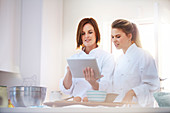 Chefs using digital tablet in kitchen