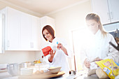 Chefs baking in sunny kitchen