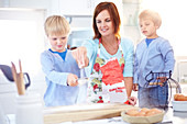 Mother and sons baking in kitchen