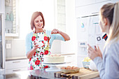 Woman frosting cake baking in kitchen