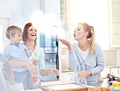 Woman blowing flour baking in kitchen