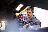 Mechanic oiling part in auto repair shop