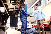 Mechanic and customer handshaking