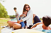 Family relaxing on blanket in sunny field