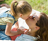 Close up mother and daughter kissing