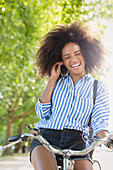 Woman with afro riding bicycle