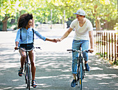 Couple holding hands riding bicycles