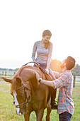Smiling couple horseback riding