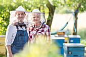 Portrait confident beekeepers near hives