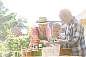 Grandparents and grandson selling honey