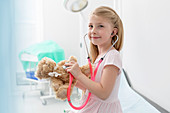 Smiling girl using stethoscope