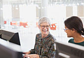 Smiling women talking at computersroom