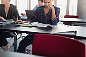 Focused woman studying with textbookroom