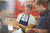 Carpenters measuring wood in workshop