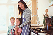 Portrait mother and daughters in kitchen
