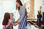 Mother and daughters holding hands