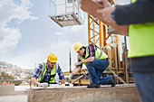 Construction workers using level tool