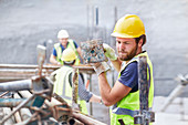 Construction worker carrying metal bar