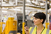 Worker using walkie-talkie in factory