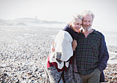 Smiling senior couple walking on beach