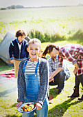 Girl with vegetable skewers at campsite