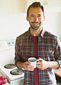 Brunette man drinking coffee in kitchen
