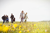 Family walking in meadow with wildflowers