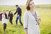 Woman holding wildflower with family