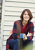 Brunette woman drinking coffee outdoors