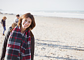 Woman in plaid scarf on sunny beach