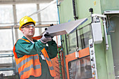Worker examining steel part