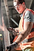 Focused worker holding steel part