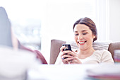Smiling woman texting with cell phone